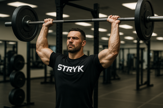 Man lifting weights in a gym wearing STRYK gym apparel - built for strength and performance 